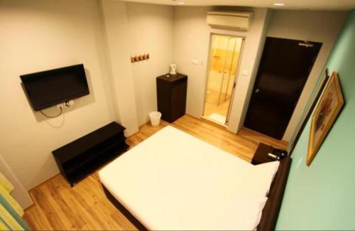 新加坡Hotel Conforto的小房间设有一张床和一台平面电视