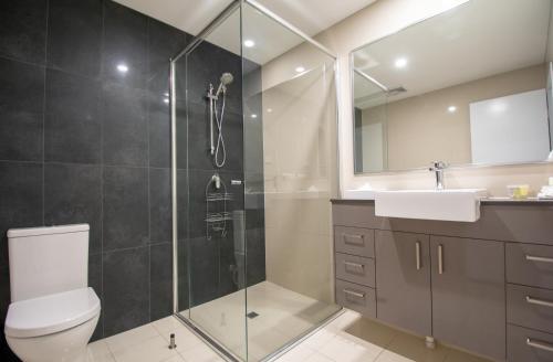 达尔文Magnum Serviced Apartments的带淋浴、卫生间和盥洗盆的浴室