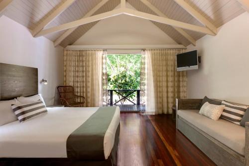 汉密尔顿岛棕榈简易别墅酒店的一间卧室配有一张大床和一张沙发