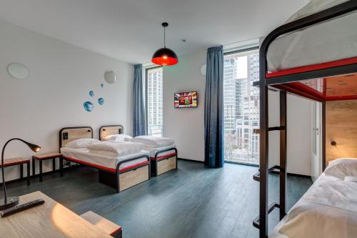 阿姆斯特丹阿姆斯特丹阿姆斯特尔梅宁阁酒店的带三张床和窗户的客房