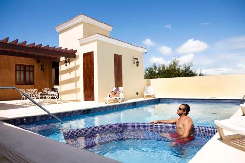 圣多明各帕拉西奥精品酒店的坐在房子旁边的游泳池里的人