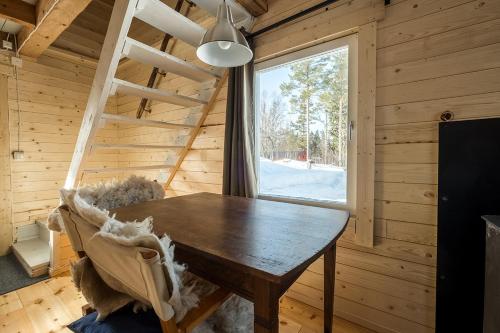 马隆Stuga Petruslogen的木制用餐室设有桌子和窗户
