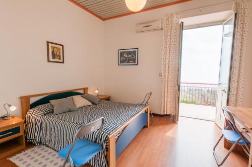 圣阿尔菲奥Al Villino Sunshine in villa con piscina ed idromassaggio的一间卧室配有一张带蓝色椅子的床和一扇窗户。