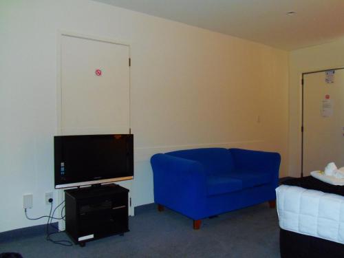 帕拉帕拉乌穆卡皮蒂林黛儿会议中心汽车旅馆的客厅配有蓝色的沙发和电视