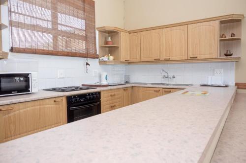 马盖特Seabrook 204 Margate RSA的厨房配有木制橱柜和白色台面