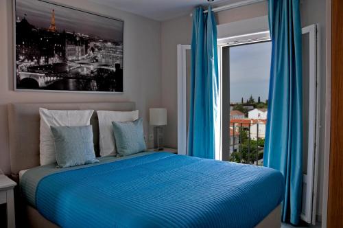 梅里达RSI公寓 的一间卧室配有一张带蓝色窗帘的床和一扇窗户