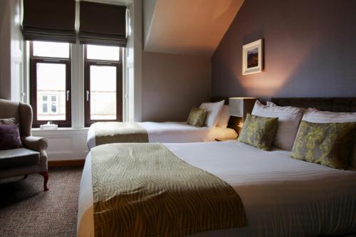 阿丁斯顿天使酒店的酒店客房,配有两张床和椅子
