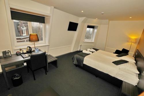 阿姆斯特丹公园景酒店的酒店客房配有一张床、一张书桌和一张书桌。