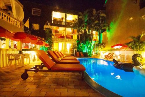 瓜拉图巴Hotel Cabana Suiça的一个带躺椅的游泳池和一间酒店