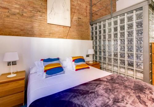 略夫雷加特河畔奥斯皮塔莱特Camp Nou Apartment的一间卧室设有一张大床和砖墙