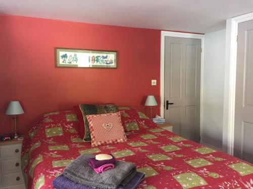 金斯布里奇Westwaterhead的红色卧室,配有带帽子的床