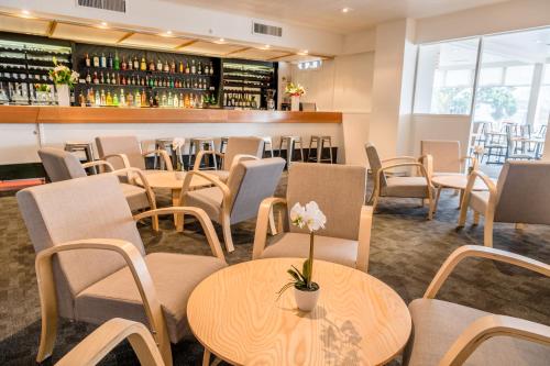 惠灵顿海湾广场酒店 的一间带桌椅的餐厅和一间酒吧