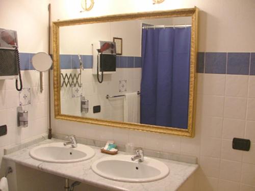 莫迪卡Hotel Relais Modica的一间带两个盥洗盆和大镜子的浴室
