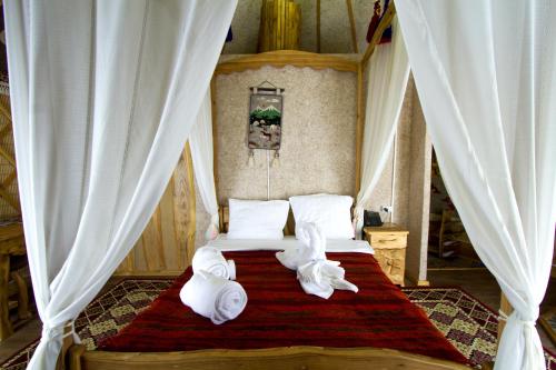 AlamedinSupara Chunkurchak的一间卧室配有带毛巾的床