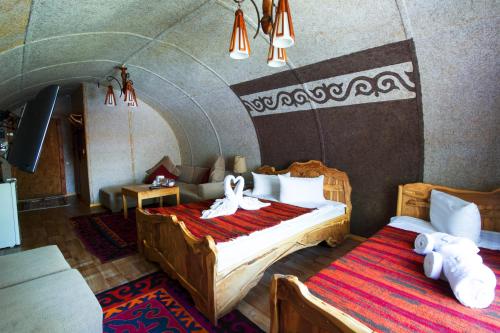 AlamedinSupara Chunkurchak的一间卧室配有两张床,卧室内配有沙发