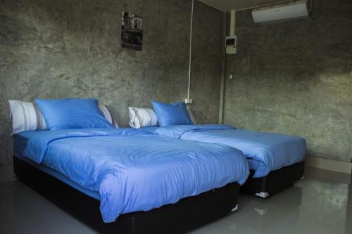 Ban Nong Chang纳维西萨查那莱经济型酒店的配有两张床铺的蓝色毯子和枕头