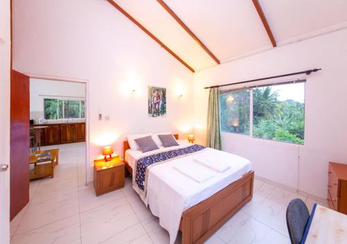昂斯布瓦洛朱莉度假屋的一间卧室设有一张床和一个大窗户