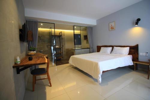 金边BK Hotel的一间带一张床和一张书桌的卧室以及一间浴室。