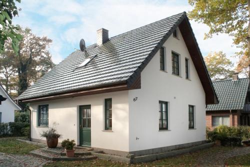 博尔滕哈根Ferienhaus "Sanddüne No.19"的黑色屋顶的白色房子