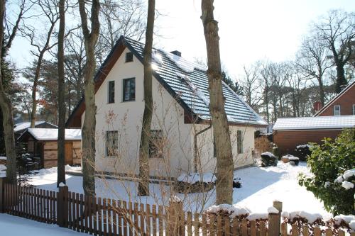 博尔滕哈根Ferienhaus "Sanddüne No.19"的雪中带围栏的白色房子