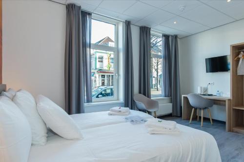 弗利辛恩城市2号沙滩酒店的酒店客房带大型白色床和窗户。