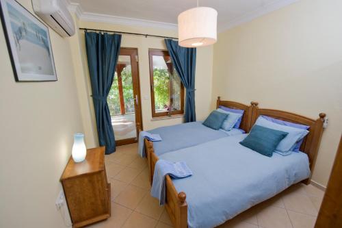 达利安Villa D'Louca的一间卧室配有两张带蓝色枕头的床