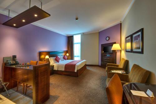 迪拜J5里马尔公寓式酒店的配有一张床和一张书桌的酒店客房