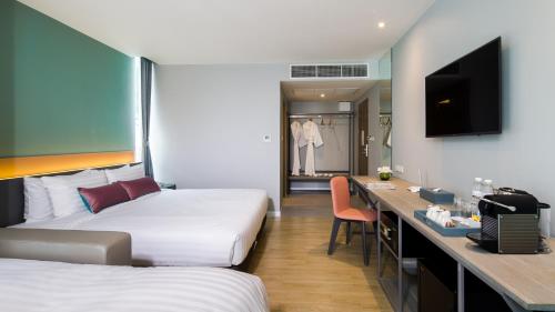 曼谷Hotel Tranz的酒店客房配有两张床和一张书桌