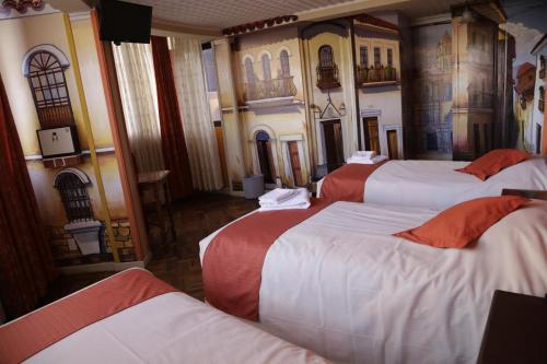 拉巴斯Isabela Hotel Suite的一间设有四张床的客房,墙上挂有绘画作品