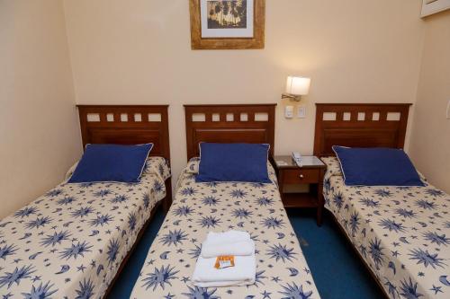 康考迪亚Hotel Federico I的配有两张蓝色和白色床单的床铺