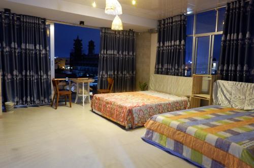 芹苴Thịnh's House的一间卧室设有两张床和一张桌子,享有美景。