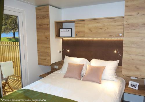 诺维格勒伊斯特拉Camping Home Adriamar的一间卧室配有一张带木制床头板的床