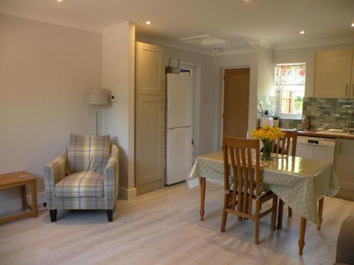 剑桥Woodfield Self-Catering apartment的厨房以及带桌椅的用餐室。
