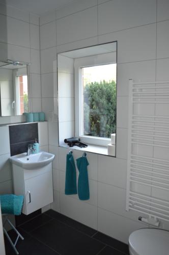 拉德贝尔根Ferienwohnung Gravemeier的白色的浴室设有水槽和窗户。