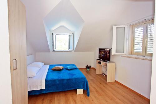 普契什查Apartmani Nila的一间卧室配有蓝色的床和电视