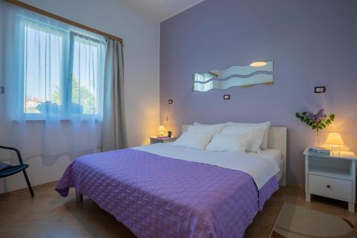 普拉Apartment Green Garden的一间卧室配有一张大床和紫色毯子