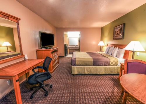 格伦代尔Chariot Inn Glendale - Pasadena的酒店客房设有一间带一张床和一张书桌的卧室