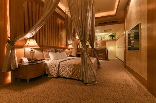 台南湖美时尚汽车旅馆的酒店客房配有床、桌子和灯具