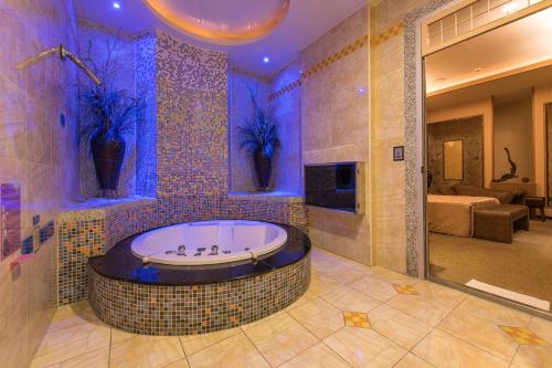 台南湖美时尚汽车旅馆的一间带按摩浴缸和紫色照明的浴室