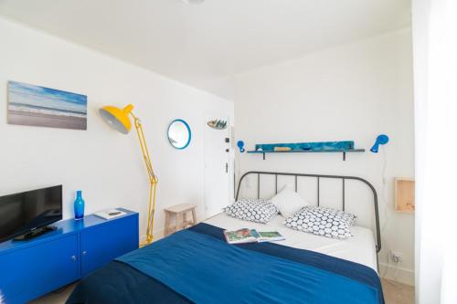 布科·莱斯白老城Le Studio Bleu de la gare的蓝色和白色的卧室设有1张床和1台电视