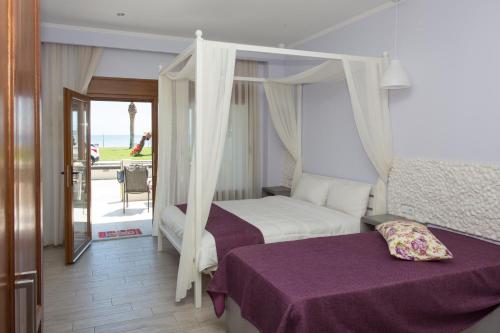 尼亚普拉莫斯Sea to See的一间卧室设有一张天蓬床和一个阳台
