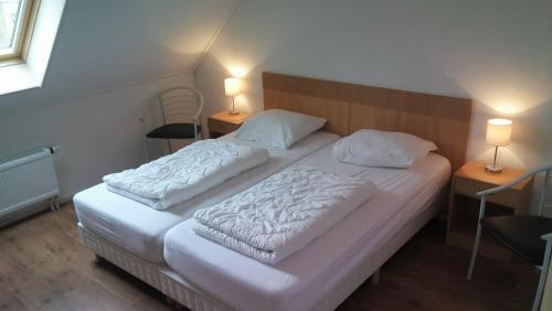 比伦Uut in Thuus 21A的一间卧室设有两张床和两张台灯。