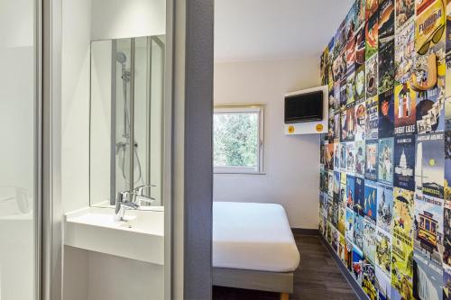 圣艾蒂安圣艾特恩酒店的浴室设有床、水槽和镜子