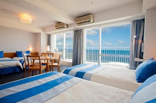北谷町The Beach Tower Okinawa的酒店客房设有两张床,享有海景。