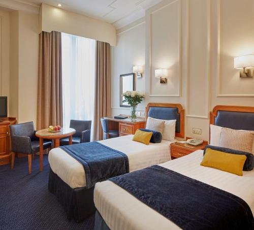 伦敦兰切斯特大门酒店的酒店客房配有两张床和一张书桌