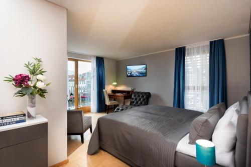 柏林柏林格律瑙大使酒店的一间卧室配有一张床和一张桌子及椅子