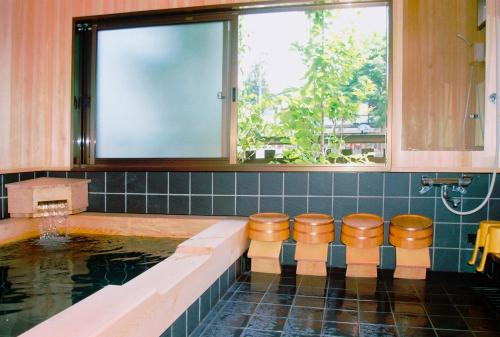 高山寿美吉旅馆的浴室设有泳池和凳子