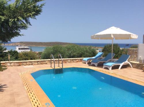 DiakoftiKythira Golden Resort的一个带两把椅子和遮阳伞的游泳池