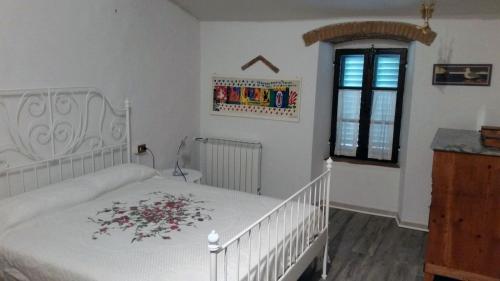 卡尔米尼亚诺弗里吉奥纳亚农家乐的卧室配有带鲜花的白色床