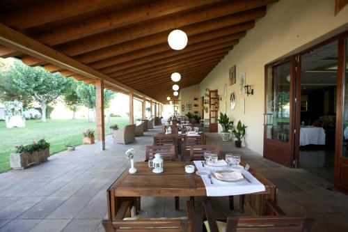 VilagrasaHotel del Carme的庭院中设有木桌椅的餐厅